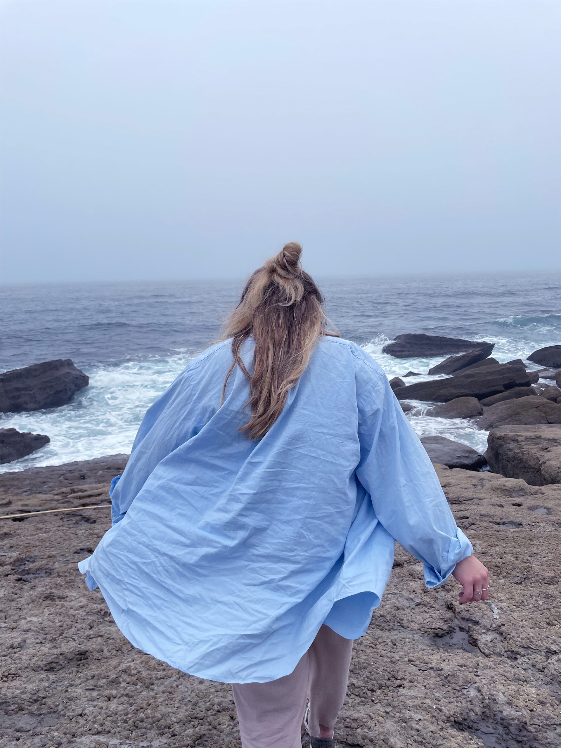 photo à la mer au Portugal, avec Émilie la fondatrice de dos, qui marche en direction de la mer